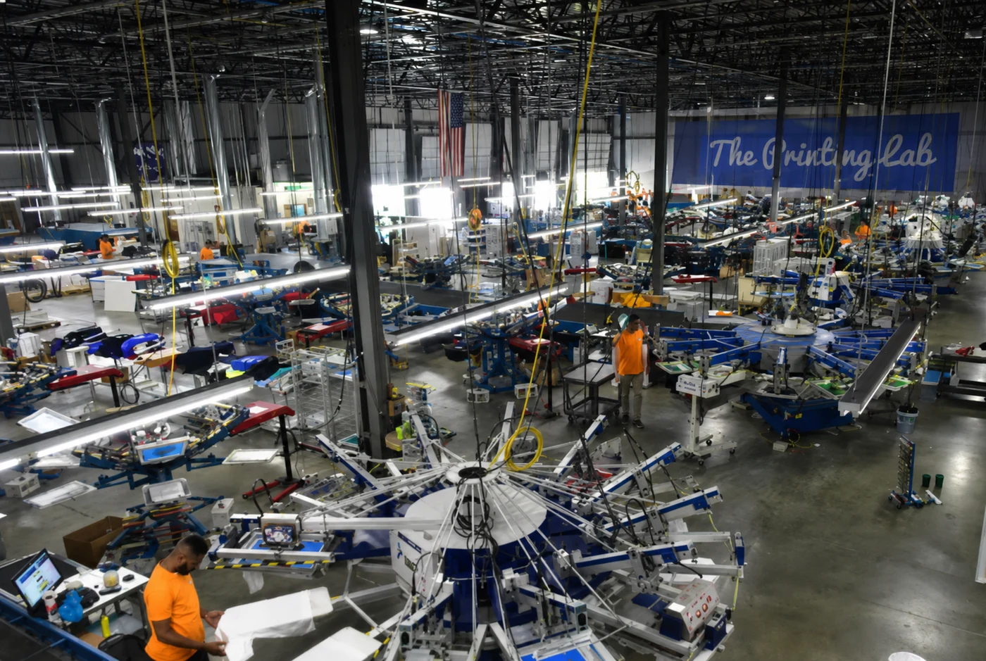 An apparel production floor with rows of screen-printing presses